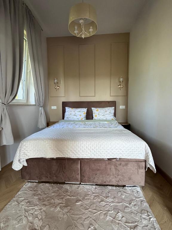 a bedroom with a large bed with white sheets and a window at Apartamenty u Gruzina in Ruda