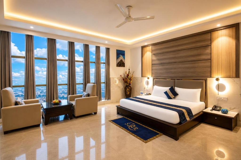 a bedroom with a king sized bed and windows at Hotel Delhi 37 by Star Group in New Delhi