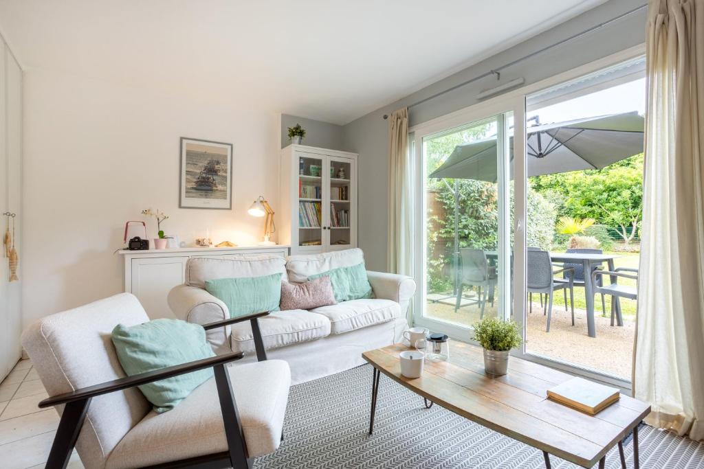 a living room with a couch and a table at L'Esprit Cap Coz in Fouesnant