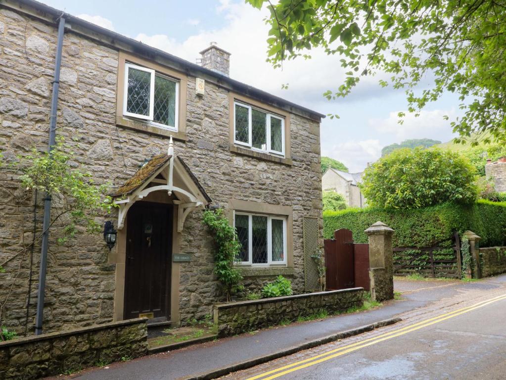 a stone house on the side of a street at The Chimes in Castleton