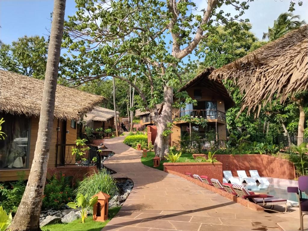 a resort with a pathway and chairs and trees at SAMA The Silver Creek in Bogmalo
