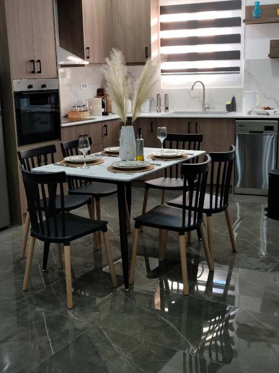 a kitchen with a table and chairs with wine glasses at Argiros Apartments in Kefalos