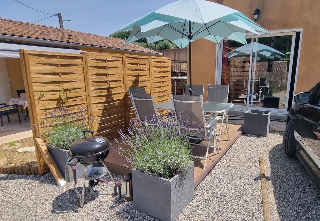 a patio with a table and chairs and an umbrella at La Casa Liberta in Salavas