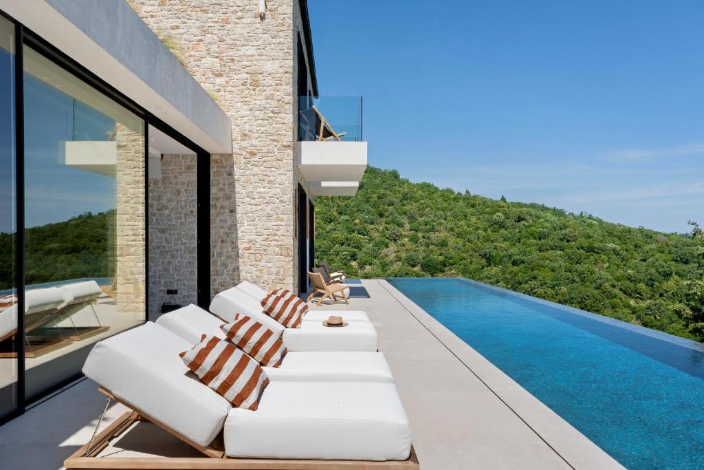 a living room with white furniture and a swimming pool at Villa Orama Corfu in Karyótikon