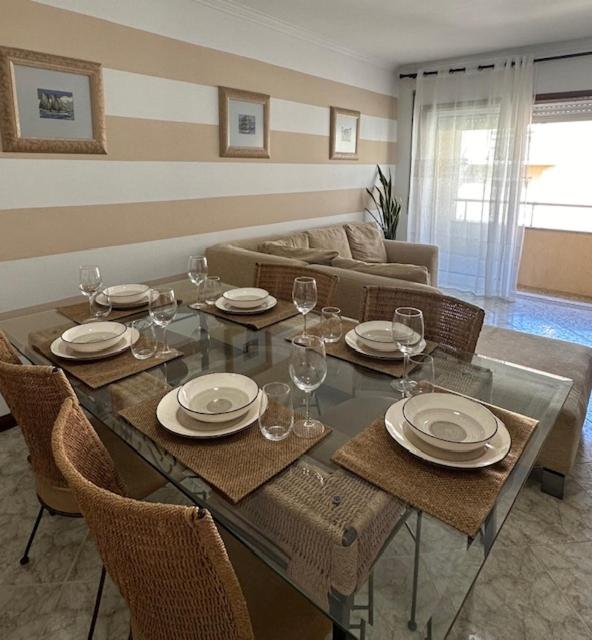 a dining room with a table with plates and wine glasses at Praia - Mar in Ovar