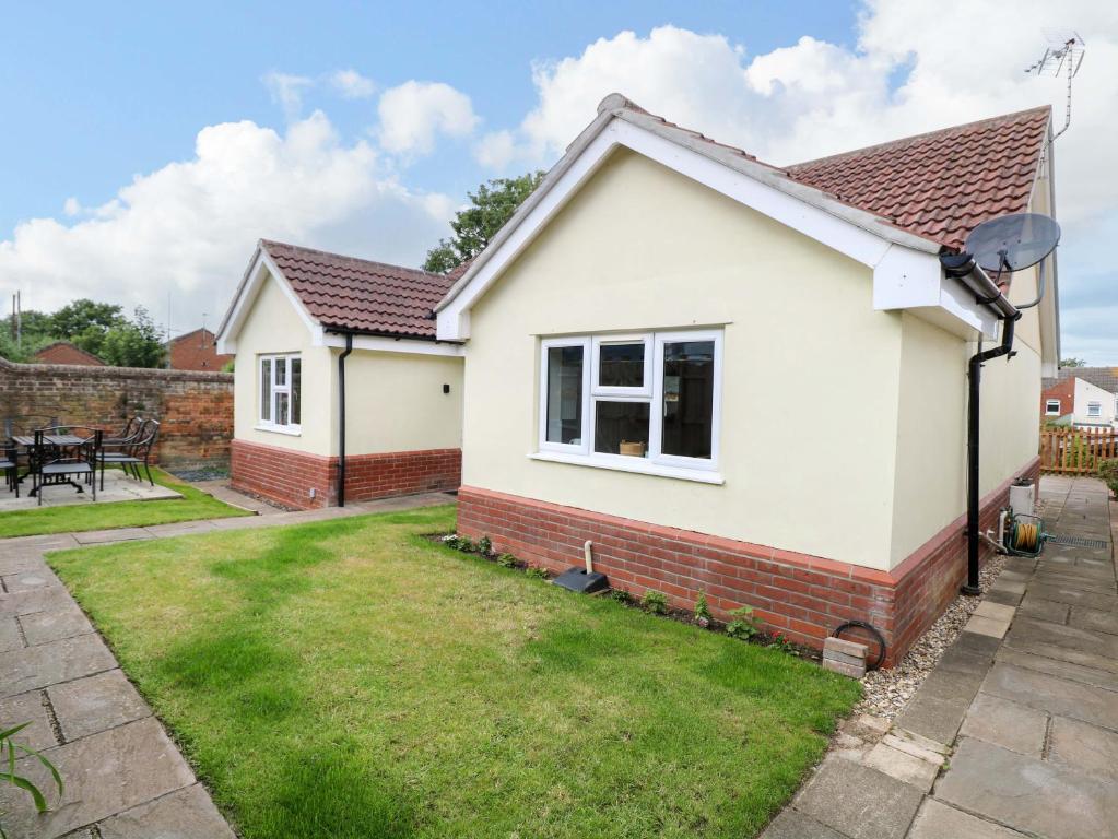 a bedroom house with a garden at The Mill House Gardens in Lowestoft