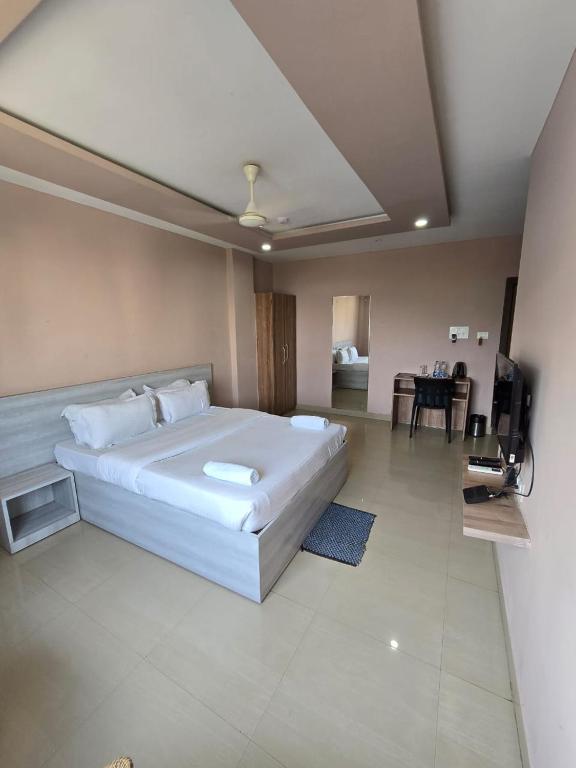 a bedroom with a large white bed and a living room at SILVER REGENCY in Guwahati