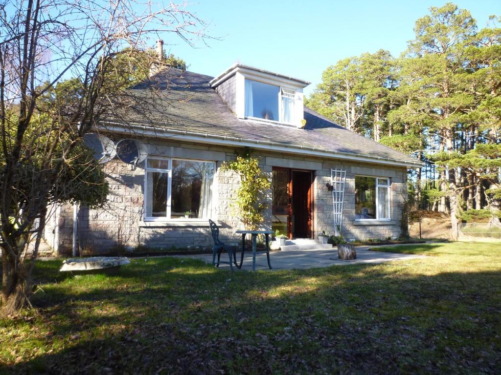 an old stone house with a front door at Camusmore House in Aviemore