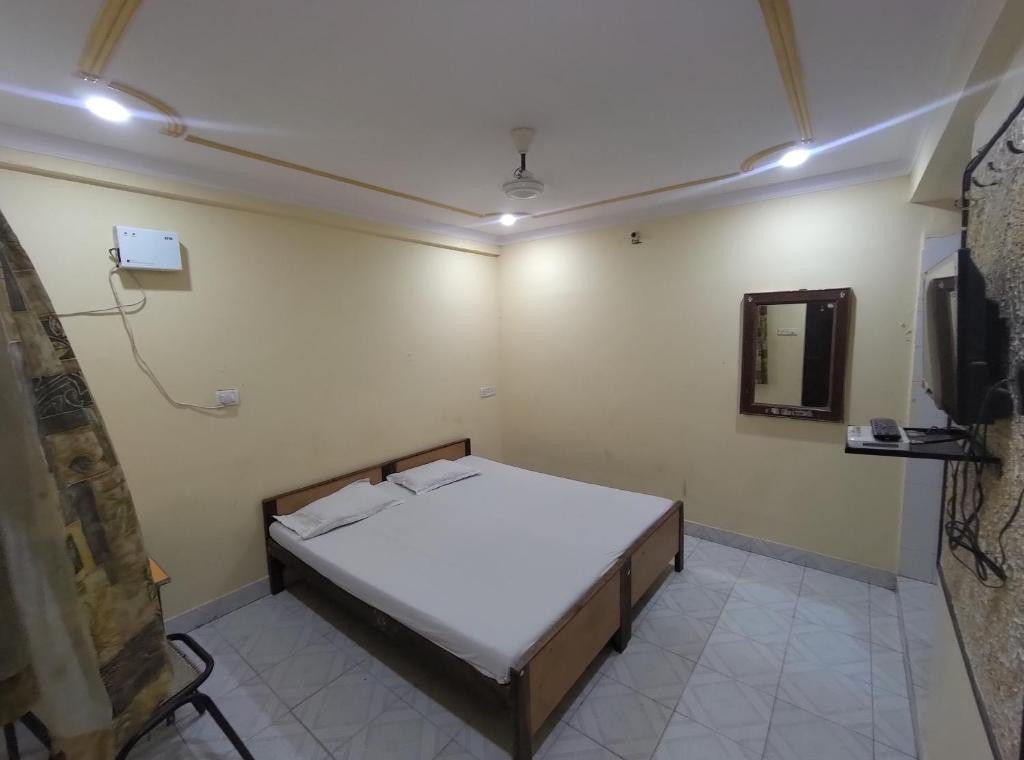 a bedroom with a bed in a room with a mirror at Hotel Geetanjali in Lucknow