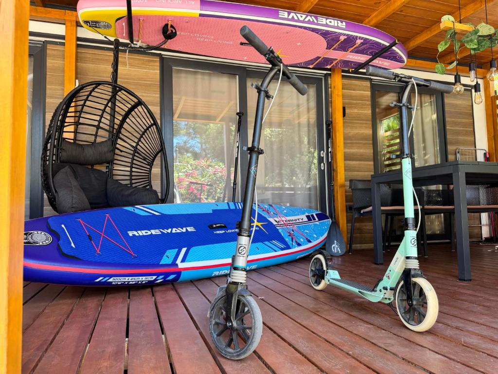 two scooters parked on a deck next to a kayak at GoLD mobile homes D&L in Biograd na Moru