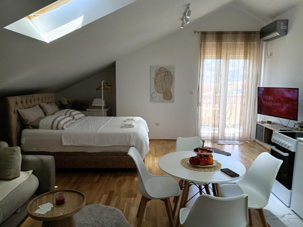 a bedroom with a bed and a table and chairs at Apartman Nadja in Podgorica