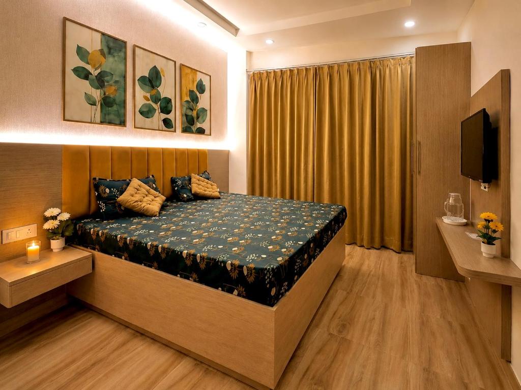 a bedroom with a bed and a television in it at The Amberwood Escape in Greater Noida