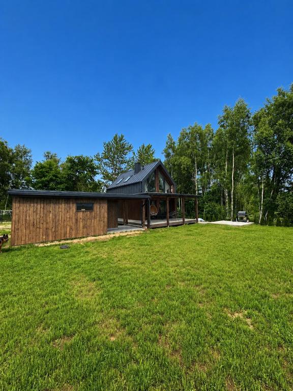 a house in a field with a large yard at Chill domek in Grzybowo