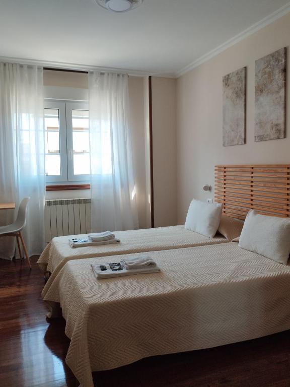 a bedroom with two beds with towels on top of them at Pensión 813 in Palas de Rei
