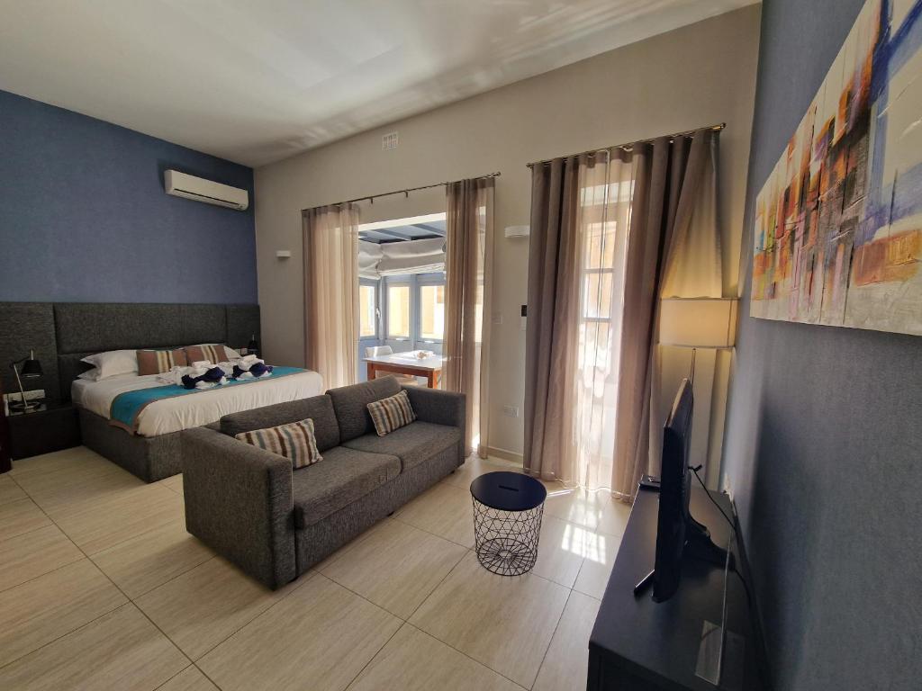 ein Wohnzimmer mit Sofa und Bett in der Unterkunft D Townhouse Boutique Suites in Sliema