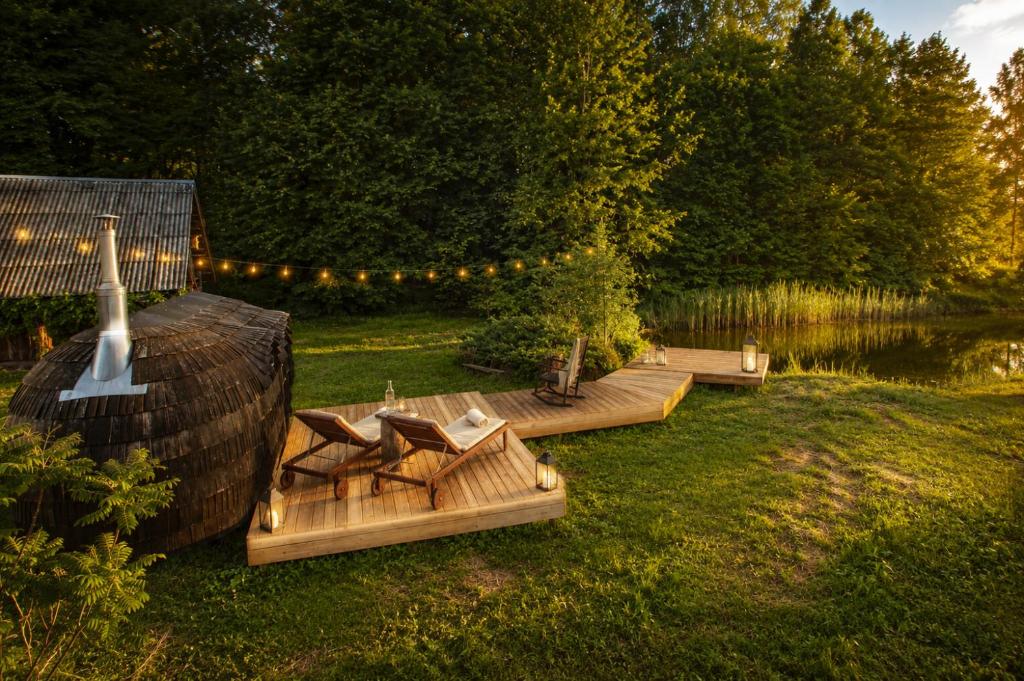 a group of benches in the grass next to a lake at Retreat House in Lauvas