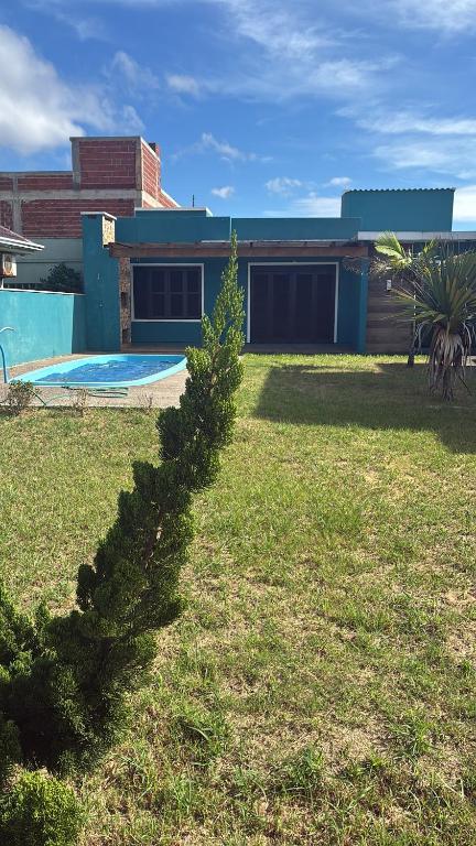 a house with a yard with a swimming pool at Casa com piscina e próxima ao mar em Imbe in Imbé