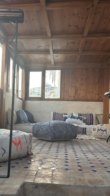 a room with three beds in a room with wooden ceilings at Dar Imran in Tangier