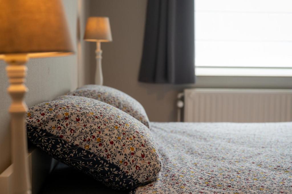 a bedroom with a bed with two pillows on it at Gîte Ô16 in Nassogne
