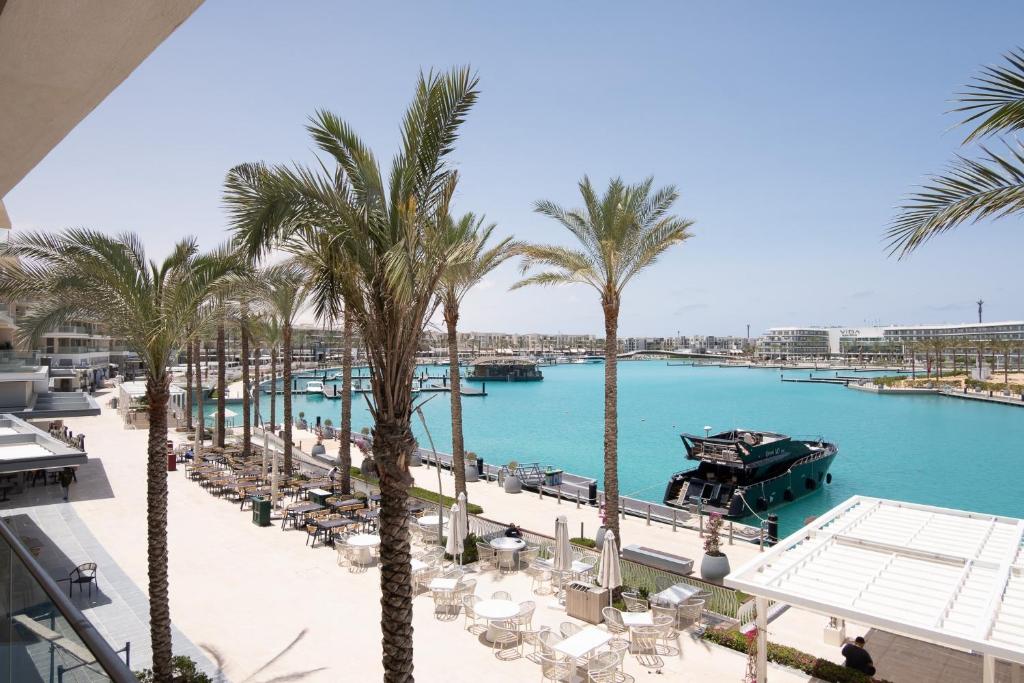 a view of a pool with palm trees and a marina at Marassi Marina Views At BirdNest in Sīdī ‘Abd ar Raḩmān