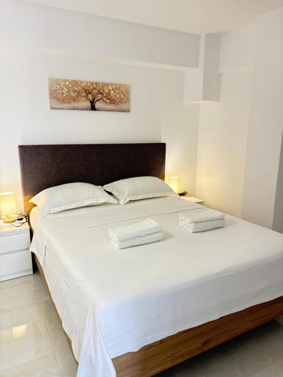 a bedroom with a large white bed with two pillows at evaxila papaflessa 机场附近 in Glyka Nera