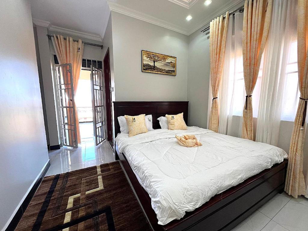 a bedroom with a large bed with white sheets at Mignon Hotel - Kalule in Kalule