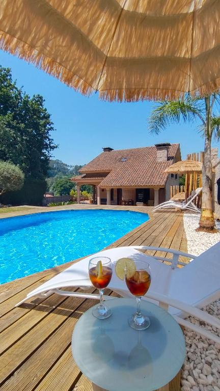two glasses of wine sitting on a table next to a swimming pool at Mazziu's villa in Cans
