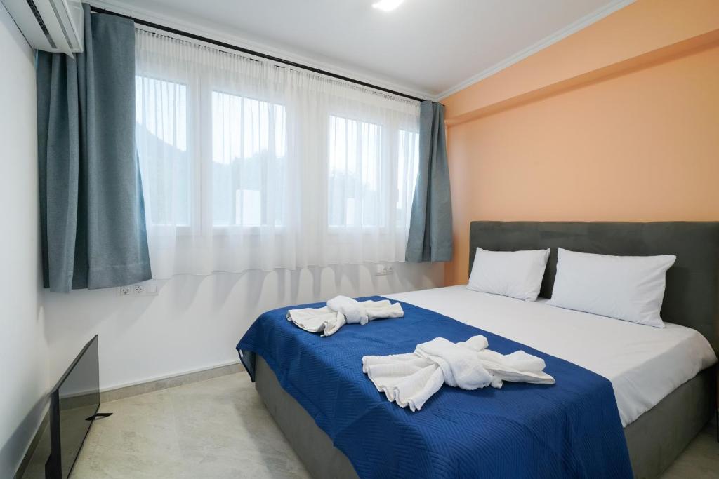 two towels on a bed in a room with a window at Studios Tasos Bi 2 in Chrysi Ammoudia