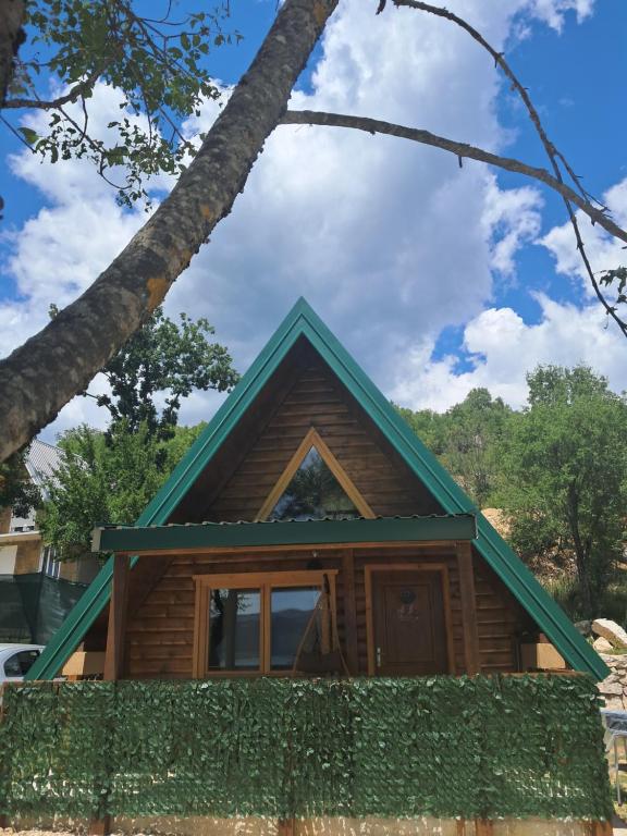 a log cabin with a green roof at Lake house Andrej & Andrea in Kuside