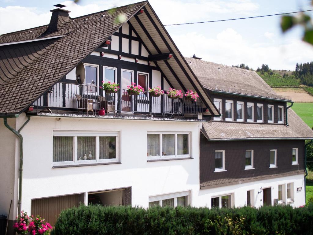 a house with flower boxes on the balconies at Dreibettzimmer mit Dusche und Wc in Lennestadt
