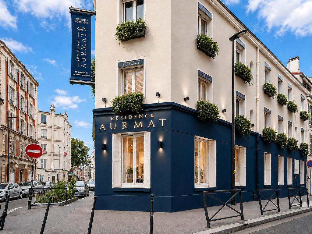 a building with a blue front on a street at Résidence AURMAT - Appart - Hôtel - Paris - Boulogne in Boulogne-Billancourt