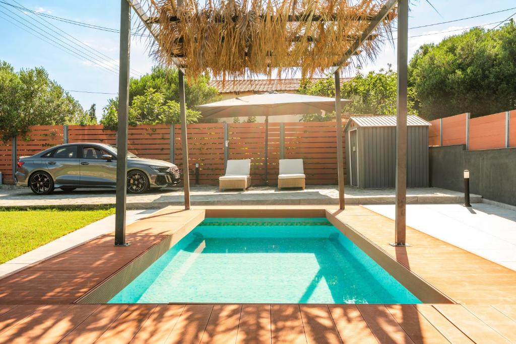 a small swimming pool in a backyard with a car at Holiday Home Potidaia in Nea Potidaea