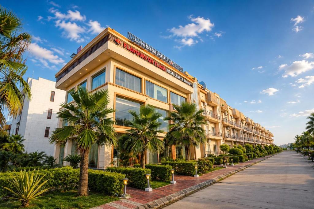 a building with palm trees in front of a street at Nandan Retreat 4-Star Hotel & Luxury Villas Near Prem Mandir, Vrindavan in Vrindāvan