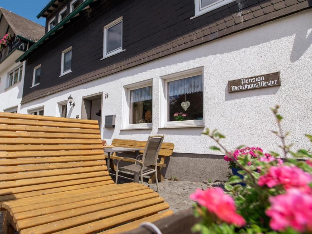 a wooden bench and table in front of a house at Ferienwohnung Schwalbennest in Lennestadt