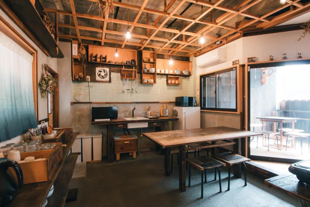ein Esszimmer mit einem Tisch und einer Küche in der Unterkunft MOUNTAinn Nagiso in Nagiso