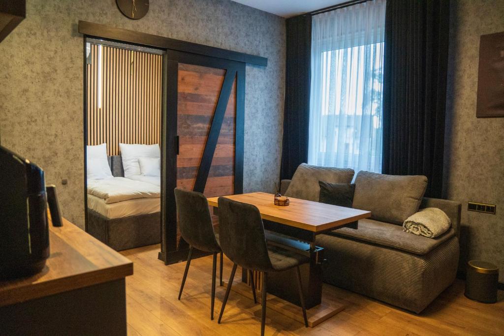 a living room with a table and a couch and a bed at Kaszmir Apartments in Opole