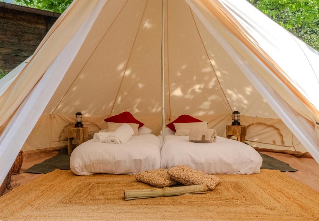 two beds in a tent with a book on the floor at Paradise Glamping in Saint Vincent