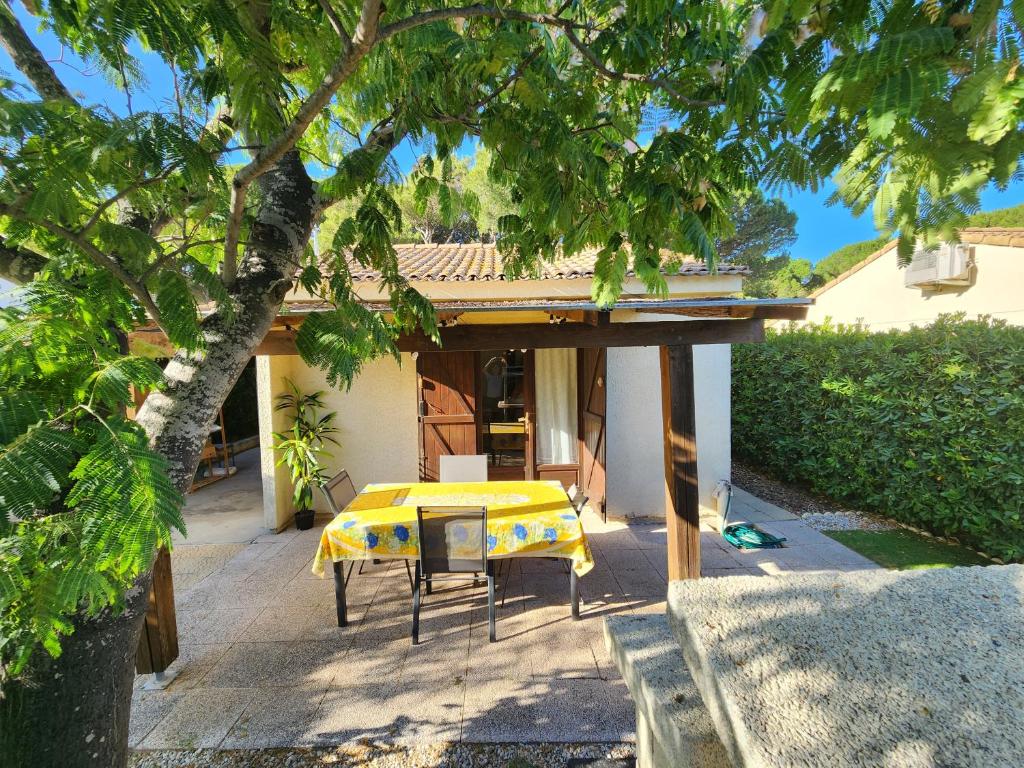 a table and chairs in front of a house at Maison à la mer in Vendres