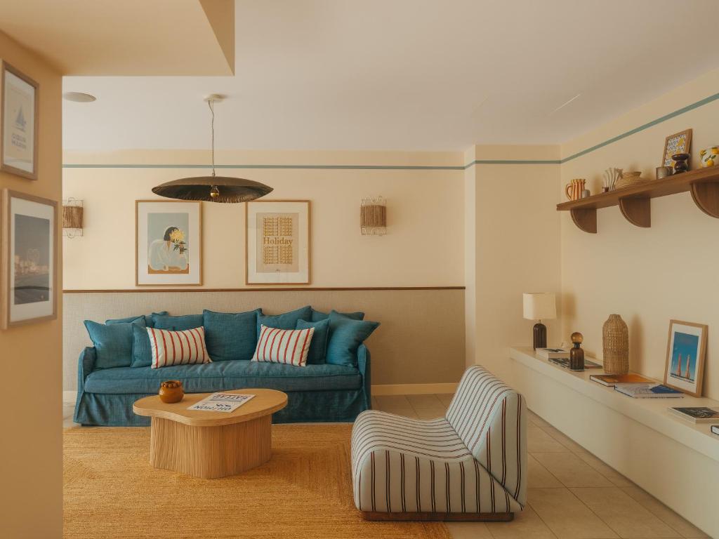 a living room with a blue couch and a table at Hotel Coeur Marin in Les Sables-d'Olonne