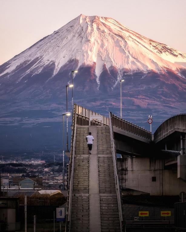 a person walking down a staircase in front of a mountain at Fuji Hyakkei - Dream Bridge in Fuji