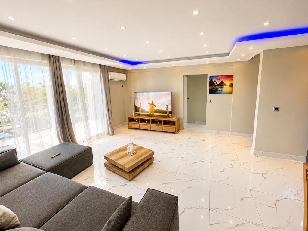 a living room with a couch and a flat screen tv at Oaks Penthouse - Flic en Flac in Flic-en-Flac