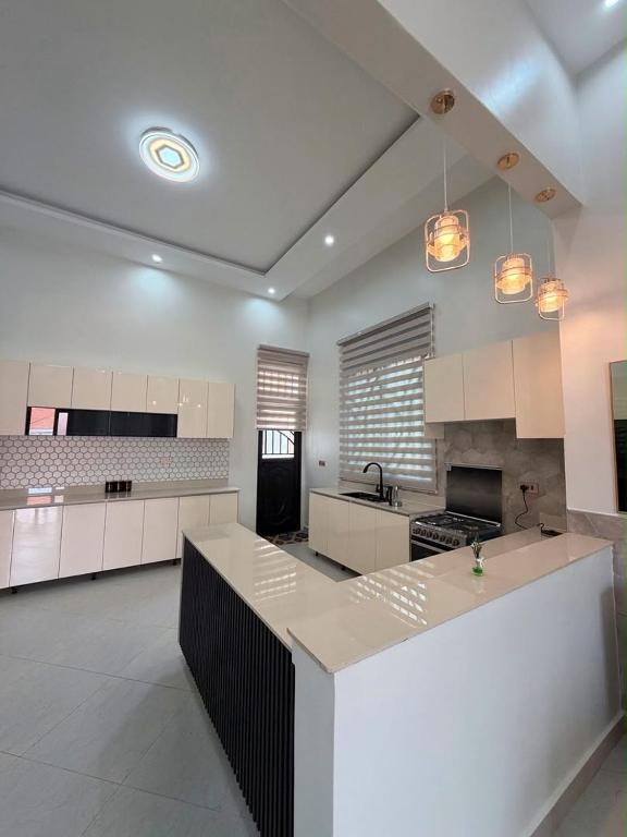 a large kitchen with white cabinets and a counter top at The Serene Sanctuary in Kampala