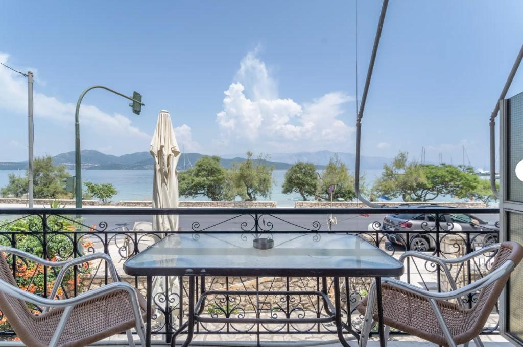 a table and chairs on a balcony with an umbrella at Giorgio studios-apartments 1 in Nikiana