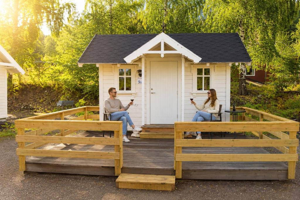 a couple sitting on the porch of a tiny house at Lillehammer Camping in Lillehammer