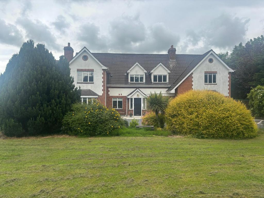 a large house with a grass field in front of it at Ivy Guesthouse in Kilkenny
