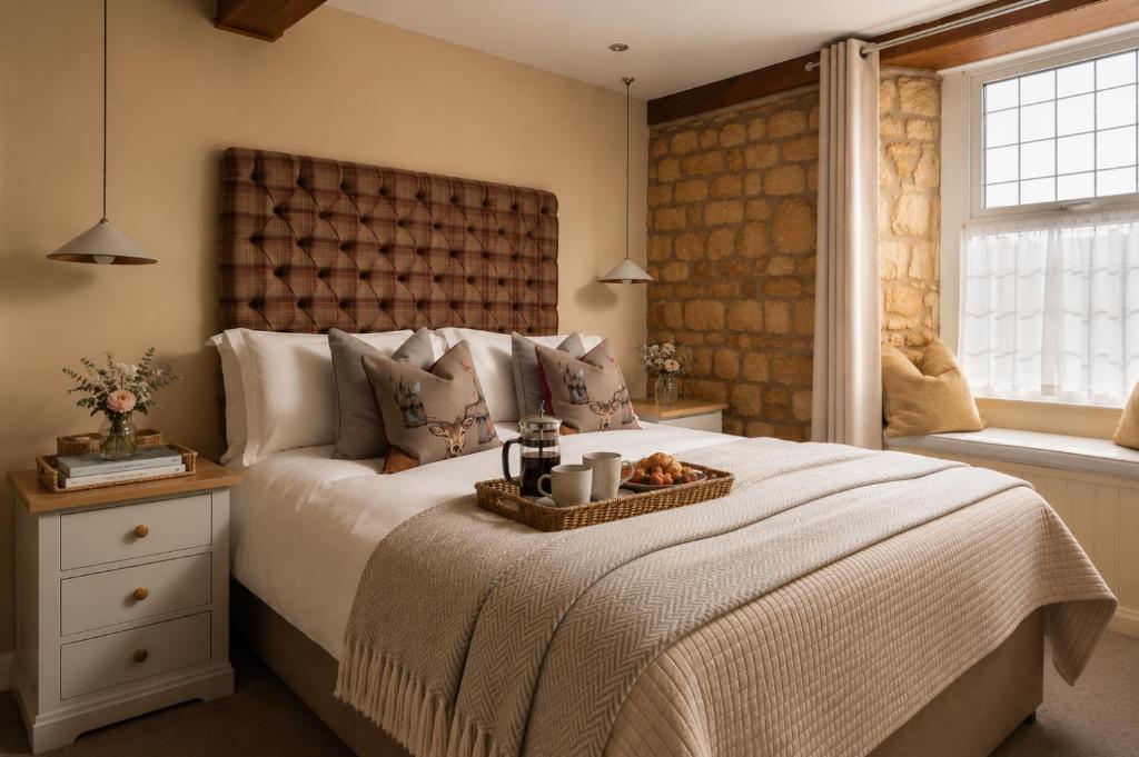 a bedroom with a bed with a tray of food on it at The Lansdowne Boutique Rooms with Breakfast - Adults Only in Bourton on the Water