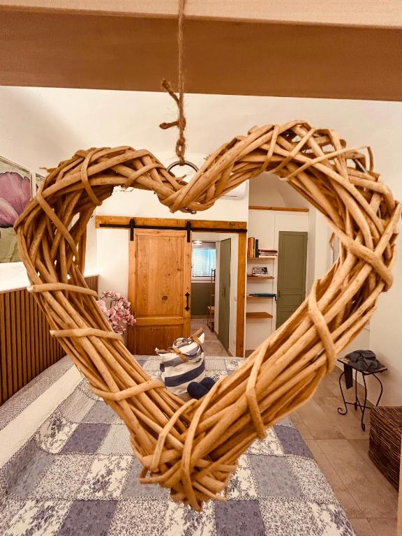 a wicker heart shaped rattan swing in a living room at Tati's Home CHARME & BIKERS in Mandello del Lario
