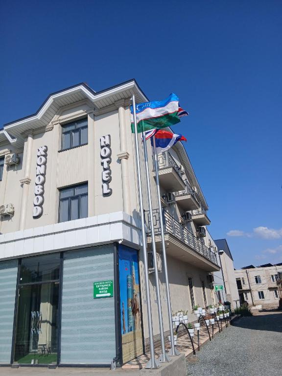 a hotel with flags in front of a building at Xonobod НОТЕL in Khiva
