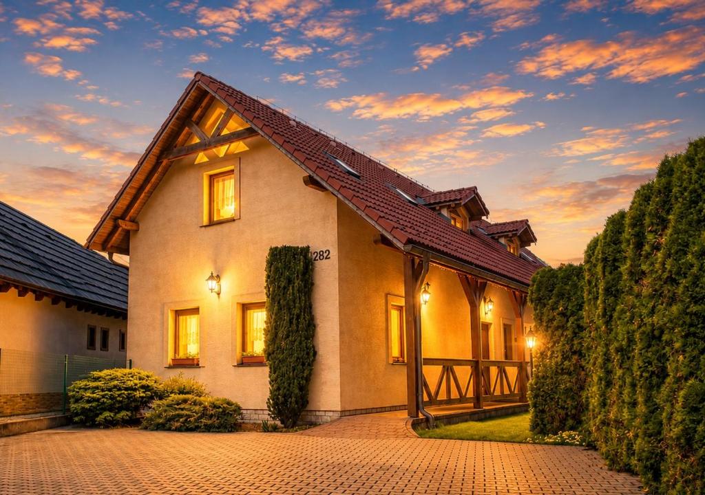 a house with a sunset in the background at Andrejkin dom in Blatnica