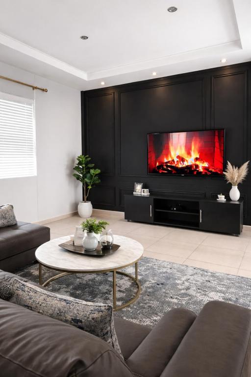a living room with a couch and a fireplace at High tide complex in Langstrand